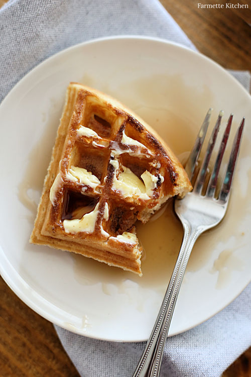 waffle with the corner gone on a plate with a fork