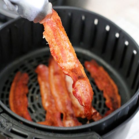 using tongs to remove air fryer bacon
