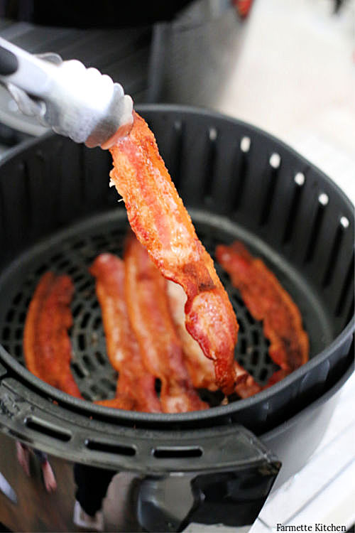 using tongs to remove air fryer bacon