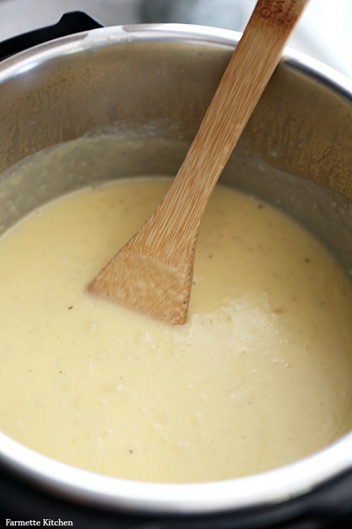 thick, creamy potato soup with a wooden spoon