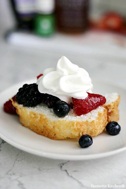 fresh fruit salad spooned over Angel food cake with whipped cream