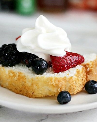 fresh fruit salad with berries and whipped cream spooned over Old Fashioned Pound Cake