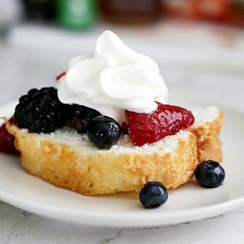 fresh fruit salad with berries and whipped cream spooned over Old Fashioned Pound Cake