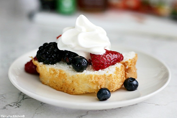 fresh fruit salad with berries and whipped cream spooned over Old Fashioned Pound Cake