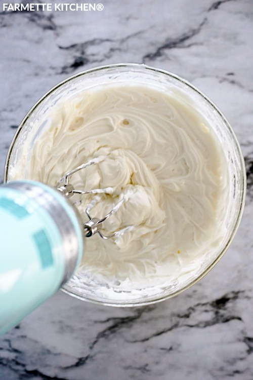 mixing cream cheese frosting with an electric mixer