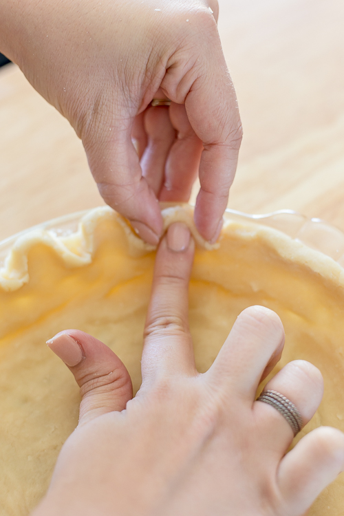 demonstrating how to crimp a pie crust border