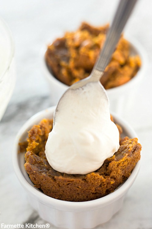 topping pumpkin cake with a big spoonful of cream cheese frosting