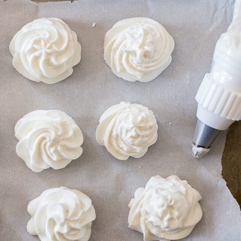 swirls of whipped cream on a baking sheet