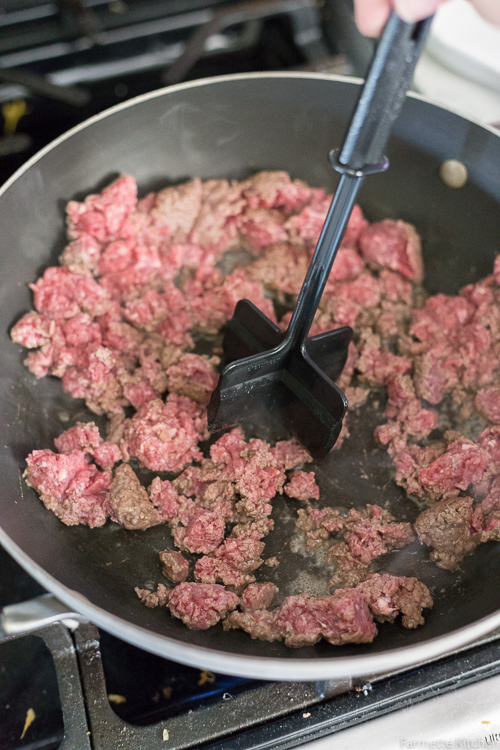 breaking up ground beef in a skillet