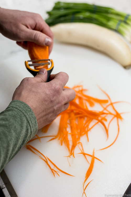 using a tool to thinly slice carrots