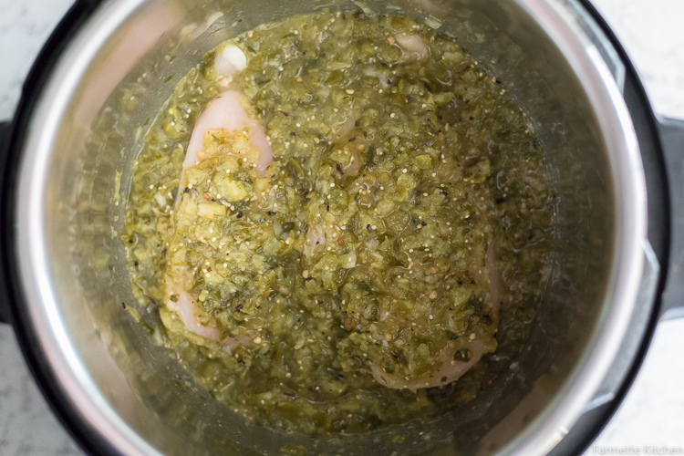 chicken covered with green salsa in an Instant Pot