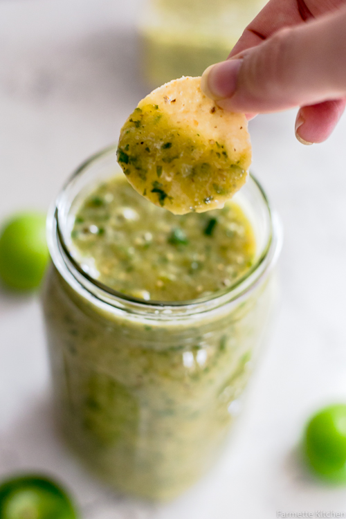scooping salsa verde with a chip