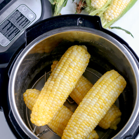four ears of cooked corn in a pressure cooker