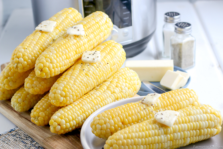 a stack of corn in front of a pressure cooker