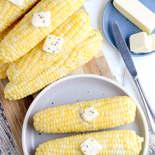 two ears of corn on a blue plate