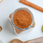 apple pie spice in a jar next to a teaspoon