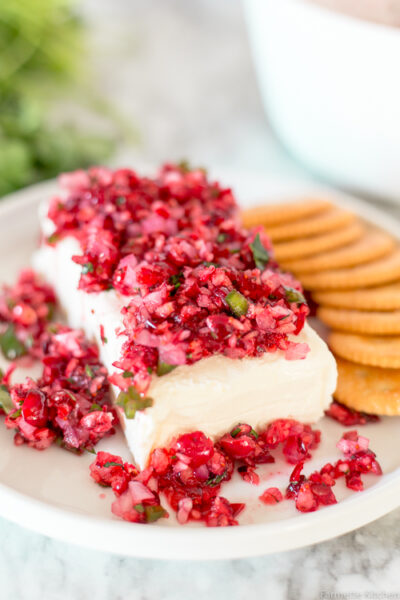 cranberry salsa over cream cheese next to crackers