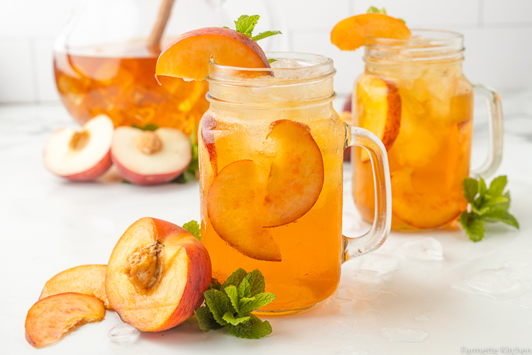 mason jar glasses with peach tea and slices of peaches