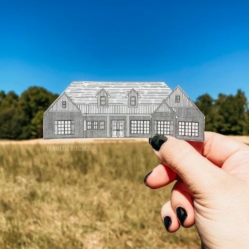 hand holding a cutout of a house