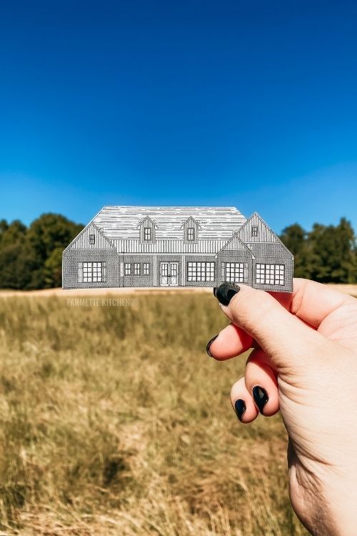 hand holding a cutout of a house